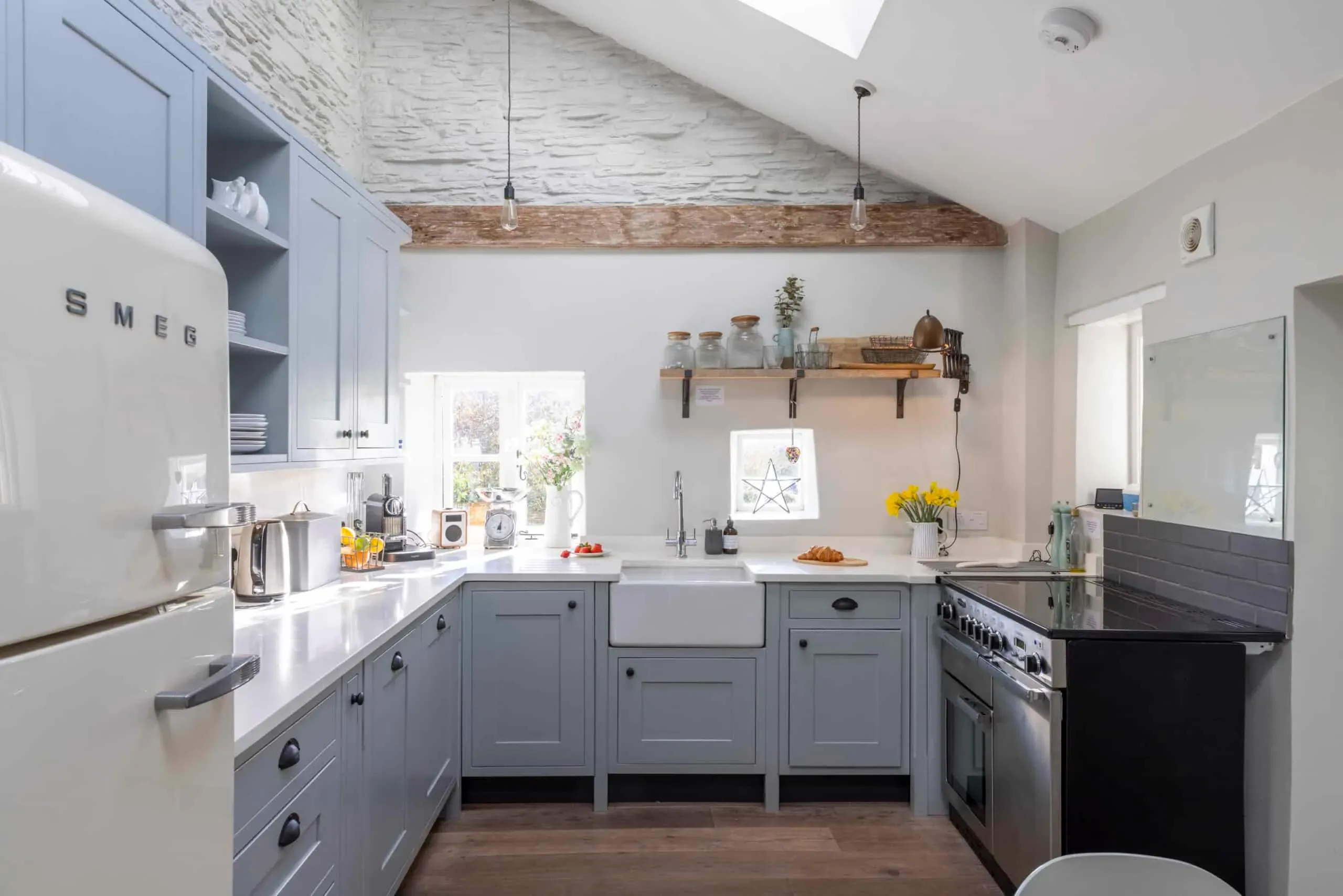 Kitchen with pale blue units, Belfast sink and range cooker