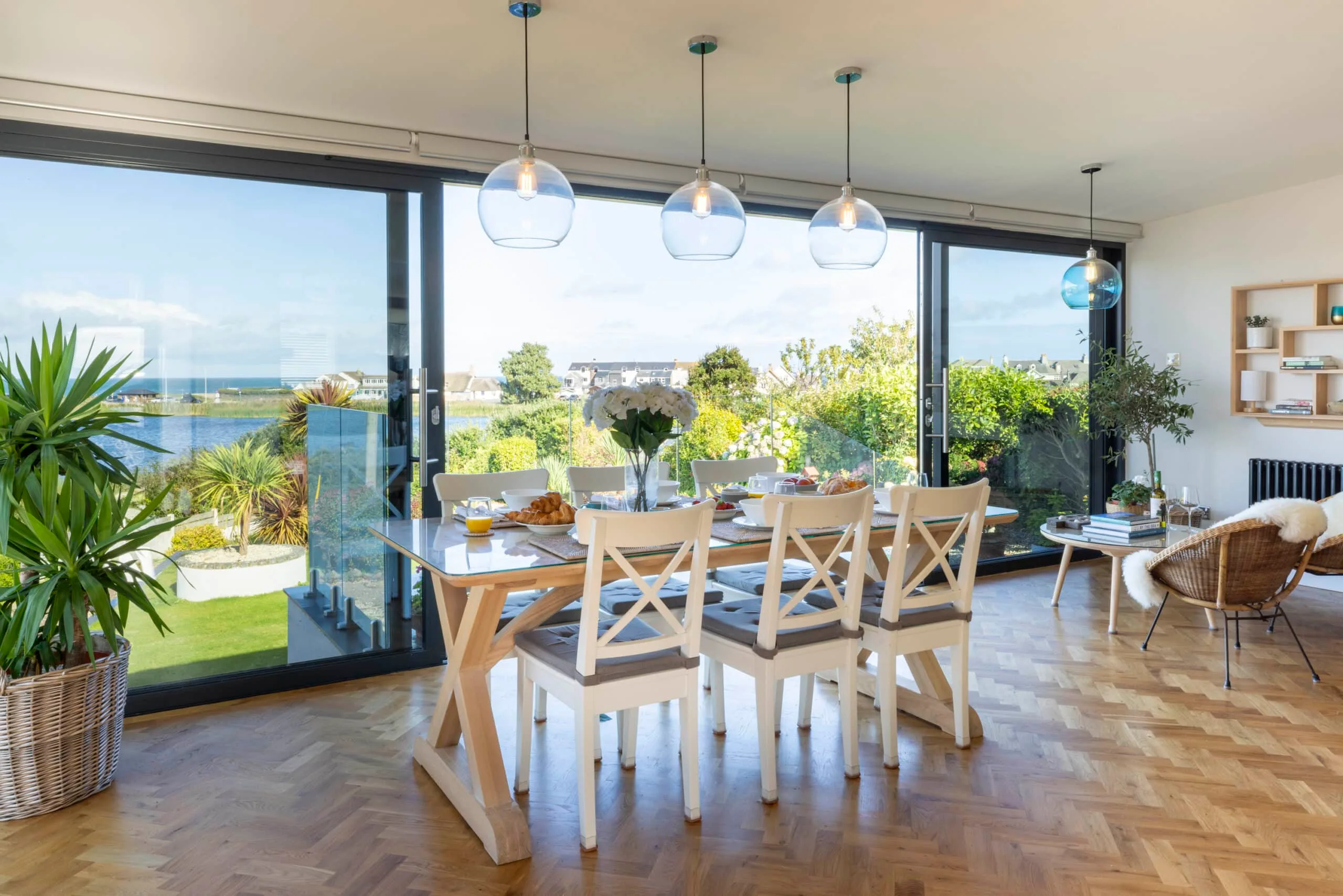 Open glazed doors onto the garden and water, breakfast laid on the dining table
